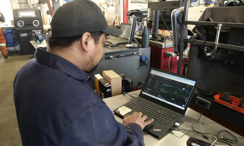 Technician pricing parts in ShopView on a laptop at the shop counter